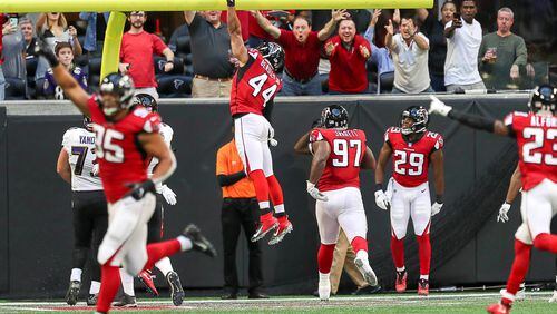 Atlanta Falcons defensive end Vic Beasley (44) dunks the football after intercepting the ball and running it back for touchdown during the first half of the game at Mercedes-Benz Stadium in Atlanta, Sunday, December 2, 2018.  (ALYSSA POINTER/ALYSSA.POINTER@AJC.COM)