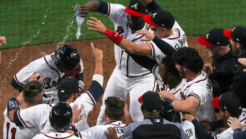 03/29/2018 -- Atlanta, GA - The Braves congratulate Nick Markakis (22) after he hit a home run securing the Braves season opener victory over the Philadelphia Phillies at SunTrust Park, Thursday, March 29, 2018. The Braves beat the Phillies, 8-5. ALYSSA POINTER/ALYSSA.POINTER@AJC.COM