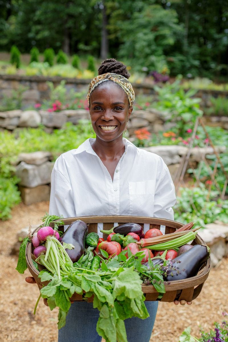 Host Jamila Norman poses with vegetables harvested from the Abbott's new garden, as seen on Homegrown, season 2.