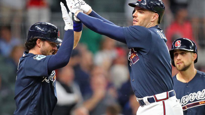 Braves rookie Dansby Swanson (left) congratulates Freddie Freeman after Freeman’s three-run homer gave the Braves a 3-2 lead over the New York Yankees in an exhibition game March 31, the Braves’ only game at SunTrust Park prior to Friday night’s home opener against the Padres. (Curtis Compton/ccompton@ajc.com)