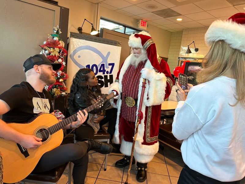 Crystal Nicole (second to left) performed at a Chick fil-A in Dunwoody for Fish 104.7's Christmas Wish program. Santa and afternoon host Beth Bacall are there, too. RODNEY HO/rho@ajc.com