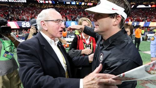 Former Georgia athletic director Vince Dooley (L) and coach Kirby Smart celebrate after the Bulldogs defeated Auburn 28-7 during the SEC Championship game at Mercedes-Benz Stadium, Dec. 2, 2017, in Atlanta.  (Curtis Compton / ccompton@ajc.com)