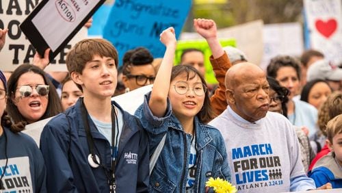 Ethan Asher, left, and Kailen Kim march with Congressman John Lewis at the March For Our Lives event in downtown Atlanta on March 24, 2018.