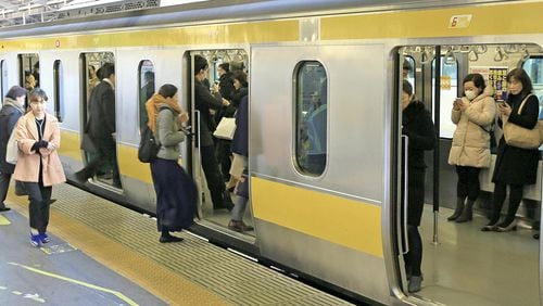 Passengers at JR Shinjuku Station in Tokyo stand in an East Japan Railway Co. train whose seats have been folded up during rush hour. PHOTO: The Japan News-Yomiuri