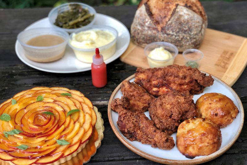 Takeout from Spring in Marietta: fried chicken dinner with honey drop biscuits; braised greens; mashed potatoes; gravy and house-made hot sauce; peach tart and polenta sourdough. 
Courtesy of Wendell Brock