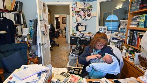 Executive office manager Antonia Harris holds 16-day-old Prince Jasper Lee Holder as she works in her office at Wayne Obstetrics and Gynecology in Jesup on Thursday, February 6, 2020. (PHOTO by Hyosub Shin / Hyosub.Shin@ajc.com)