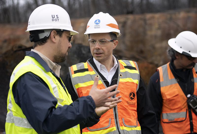U.S. Secretary of Transportation Pete Buttigieg (center) visits with Department of Transportation Investigators at the site of the derailment on Feb. 23 2023, in East Palestine, Ohio. On February 3rd, a Norfolk Southern Railways train carrying toxic chemicals derailed causing an environmental disaster. (TNS)