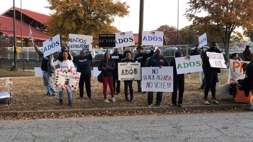 ADOS members held signs outside the Democratic presidential debate at Tyler Perry Studios in Atlanta in November. CONTRIBUTED