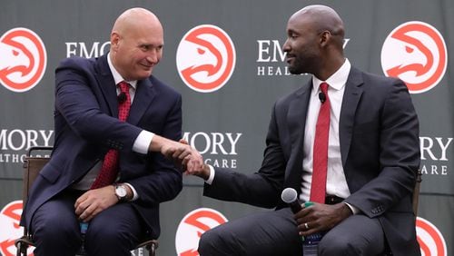 The Atlanta Hawks general manager Travis Schlenk introduces Lloyd Pierce as the 13th full-time coach in the Atlanta history of the NBA basketball franchise on Monday, May 14, 2018, in Atlanta. Pierce joins the Hawks after spending the past five seasons as an assistant coach with the 76ers.