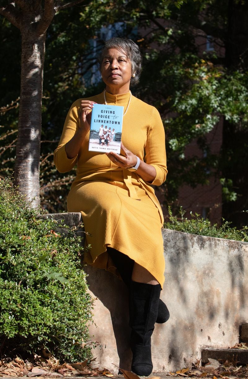 October 18, 2021 - Athens Clarke County - Hattie Whitehead poses with her book, "Giving Voice to Linnentown," outside of Creswell Hall on the University of Georgia campus on Monday, Oct. 18, 2021. Creswell Hall and the surrounding area were once a neighborhood called Linnentown, of which Whitehead is a former resident. 
(Sarah White for the Atlanta Journal Constitution)