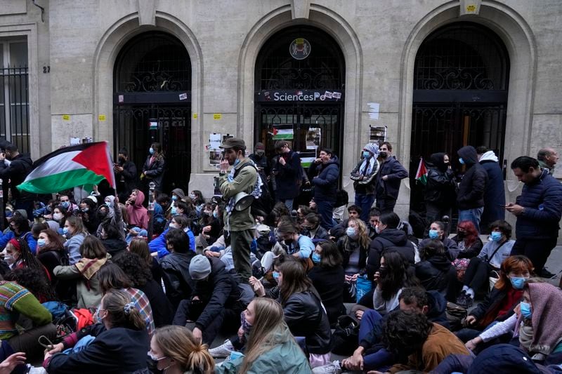 Students stage a sit in in front of Sciences-Po university in Paris Friday, April 26, 2024. Students in Paris inspired by Gaza solidarity encampments at campuses in the United States blocked access to a campus building at a prestigious French university Friday, prompting administrators to move all classes online. The pro-Palestinian protest at the Paris Institute of Political Studies, known as Sciences Po, came two days after police broke up a separate demonstration at one of the university's amphitheaters. (AP Photo/Michel Euler)