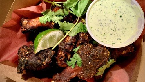 The smoked wings at Little Rey are dressed with salsa macha, a mixture of dried chiles and peanuts. Henri Hollis/henri.hollis@ajc.com