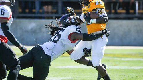 Kennesaw State running back Darnell Holland (33) is tackled by Gardner-Webb linebacker Aaron Cook (26) during the second half of an NCAA college football game, Saturday, Oct. 17, 2015, in Kennesaw, Ga. Holland rushed for 59 yards in the Owls’ 36-21 loss to Liberty on Saturday. (Photo/John Amis)