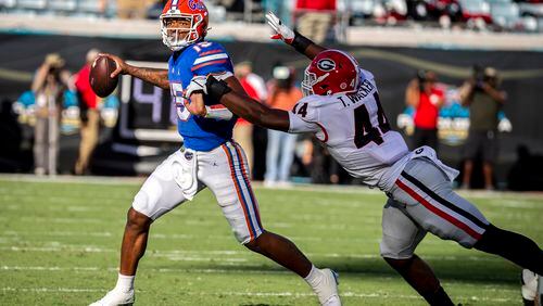 Gators quarterback Anthony Richardson tries to elude Bulldogs defensive lineman Travon Walker last season  in Jacksonville, Fla. (Stephen B. Morton/Atlanta Journal-Constitution)