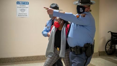 Rep. Park Cannon (D-Atlanta) is escorted out of the Georgia Capitol by Georgia state troopers after being asked to stop knocking on a door that led to Gov. Brian Kemp's office while Kemp was signing SB 202 behind closed doors on day 38 of the legislative session. (Alyssa Pointer/Atlanta Journal-Constitution/TNS)