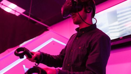 Curtis Baillie, an employee at Liberty Virtual Reality and senior at Rowan University, plays a virtual reality game where he’s flying at the virtual reality arcade on Friday, March 30, 2018 at Rowan University in Glassboro, N.J. (Sydney Schaefer/Philadelphia Inquirer/TNS)