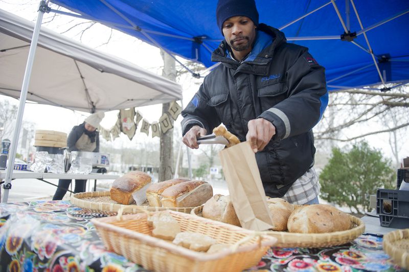 Robert Roebuck bags up fresh bread at the Decatur Farmers Market on Saturday, January 4, 2014. The freezing temperatures did not keep people away from the market which is held throughout the year.