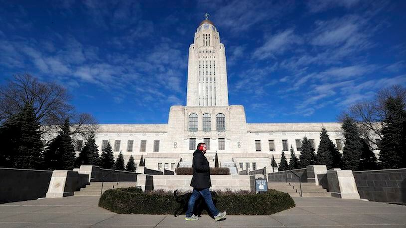 A pedestrian walks past the Nebraska State Capitol building in Lincoln, Neb., on Wednesday, Jan. 4, 2017. Lancaster County is among the most evenly split on political lines of any major county in the nation. (AP Photo/Charlie Neibergall)