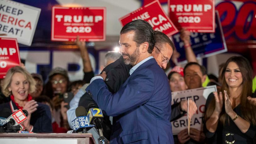 U.S. Congressman Doug Collins is embraced by Donald Trump Jr. during a Republican rally Thursday in the parking lot at the Georgia Republican Party's headquarters in Buckhead. Collins is leading President Donald Trump's effort seeking a recount in Georgia. (Alyssa Pointer / Alyssa.Pointer@ajc.com)