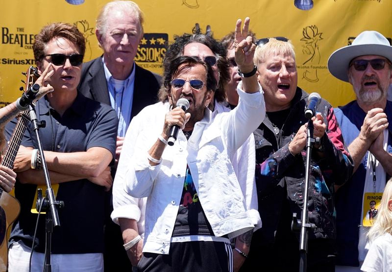 Ringo Starr, center, addresses the crowd while surrounded by friends onstage during his annual Peace & Love Birthday Celebration, Thursday, July 7, 2022, in Beverly Hills, Calif. Starr celebrated his 82nd birthday Thursday. (AP Photo/Chris Pizzello)