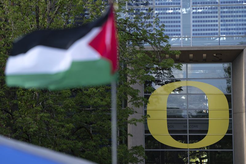 A Palestinian flag flutters in the wind as University of Oregon students set up a tent encampment at the university to protest the Israel-Hamas war on Monday, April 29, 2024, in Eugene, Ore. (AP Photo/Jenny Kane)