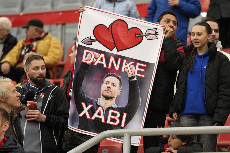 Supporters hold a banner, reading „Thanks Xabi" prior the German Bundesliga soccer match between Bayer Leverkusen and TSG Hoffenheim at the BayArena in Leverkusen, Germany, on March 30, 2024. Excitement was building in Leverkusen, Germany on Sunday ahead of local team Bayer Leverkusen’s expected Bundesliga title win after an outstanding season so far. (AP Photo/Martin Meissner)
