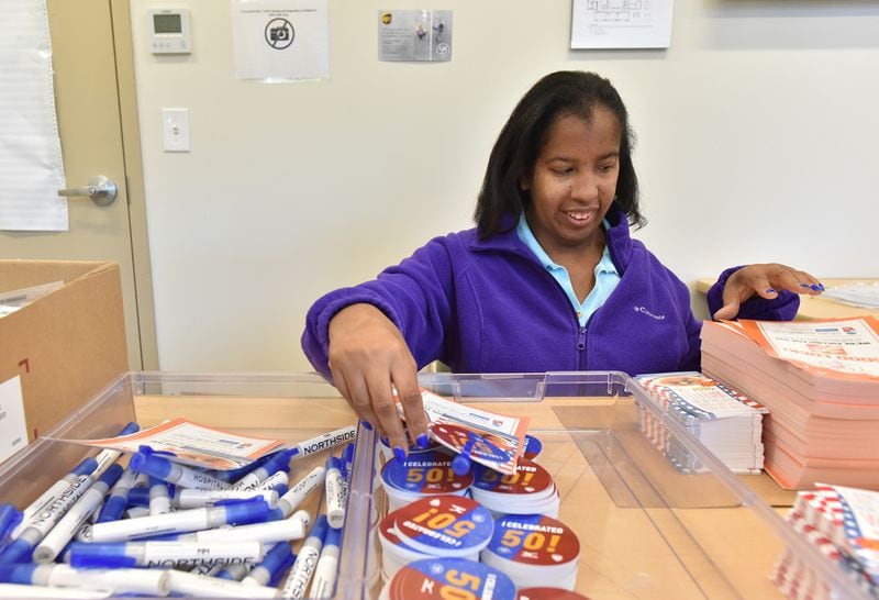 June 14, 2019 Atlanta - Dayna Livingston, client at the center and volunteer, assembles bags of AJC Peachtree Road Race gift at Jewish Family & Career Services on Friday, June 14, 2019.  HYOSUB SHIN / HSHIN@AJC.COM