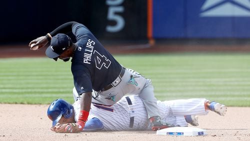 NEW YORK, NY - APRIL 03: Brandon Phillips #4 of the Atlanta Braves makes the out as Travis d&#039;Arnaud #18 of the New York Mets slides into second in the seventh inning during Opening Day on April 3, 2017 at Citi Field in the Flushing neighborhood of the Queens borough of New York City. (Photo by Elsa/Getty Images)