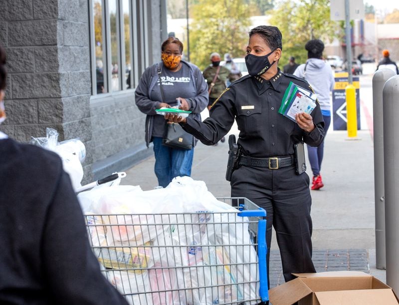 DeKalb Police Chief Mirtha Ramos hands out some of the 10,000 COVID-19 care kits at a Lithonia Walmart on November 25, 2020.     STEVE SCHAEFER / SPECIAL TO THE AJC 