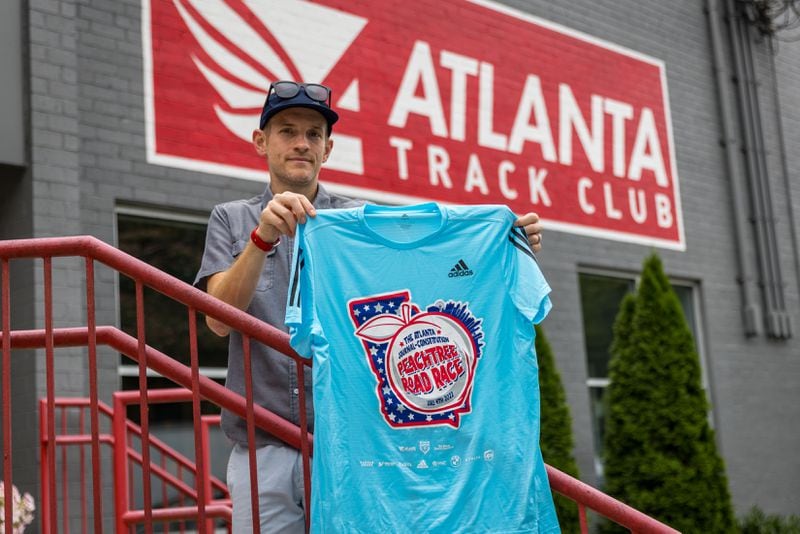Jay Holder, vice president for marketing and communications at the Atlanta Track Club, displays the award winning t-shirt design for the 2022 Peachtree Road Race on Wednesday, June 29, 2022. (Arvin Temkar / arvin.temkar@ajc.com)