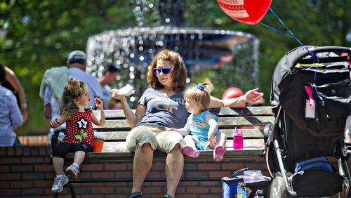 Tammy Shiflett (center) eats a snack with her granddaughter Lowery Collins (left) and niece Claire Shiflett as they sit on a bench during the May-retta Daze Arts & Craft Festival at Glover Park in Marietta on Sunday, May 4, 2014.