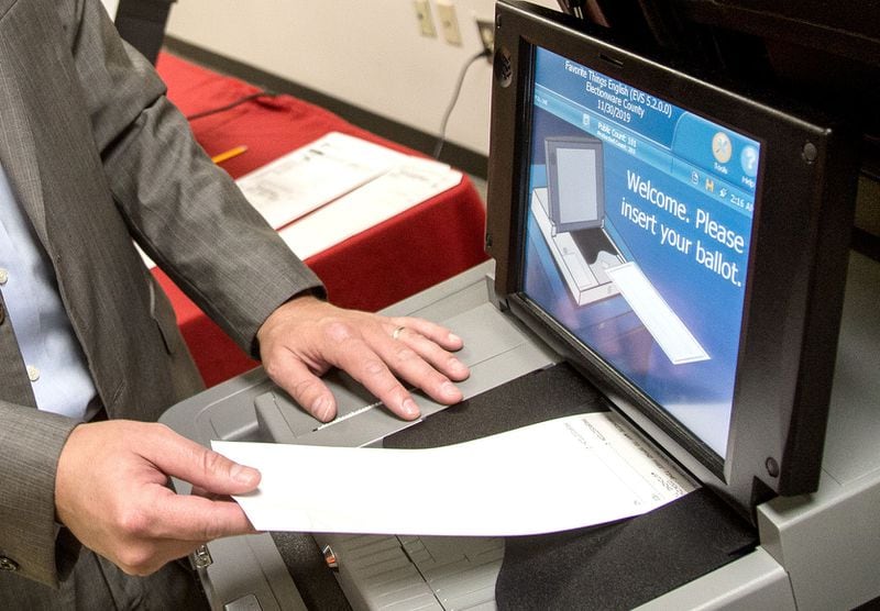 Voters insert their paper ballots into optical scanning machines for tabulation.