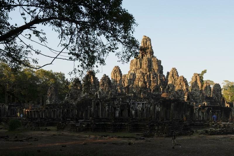 A view of Bayon temple at Angkor Wat temple complex in Siem Reap province, Cambodia, Tuesday, April 2, 2024. The Angkor site is one of the largest archaeological sites in the world, spread across some 400 square kilometers (155 square miles) in northwestern Cambodia. It contains the ruins of Khmer Empire capitals from the 9th to 15th centuries, including the temple of Angkor Wat, featured on several Cambodian banknotes, such as the 2,000 riel note depicting rice farmers working fields around the temple, as well as the country's flag. (AP Photo/Heng Sinith)