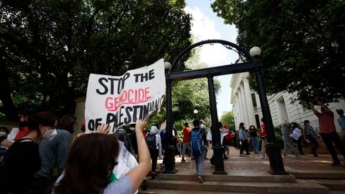 Dozens of Pro-Palestinian protesters chant as they cross the iconic arch on the University of Georgia campus in Athens following arrests on Monday, April 29, 2024. (Miguel Martinez / AJC)