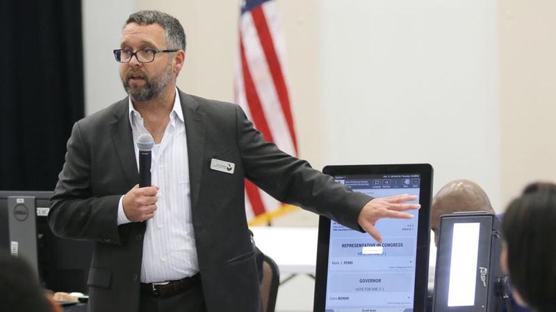 Eric Coomer from Dominion Voting demonstrates his company's touch screen tablet that includes a paper audit trail. Voting machine companies demonstrated their products Thursday, Aug. 30, 2018, at the second meeting of Secretary of State Brian Kemp's Secure, Accessible & Fair Elections Commission in Grovetown. The commission was evaluating whether to switch from electronic voting machines to ones that offer paper ballots for verification and auditing. Vendors present included Clear Ballot, Unisyn Voting Solutions, Smartmatic, Election Systems & Software, Hart InterCivic, and Dominion Voting. (Bob Andres / Bob.Andres@ajc.com)