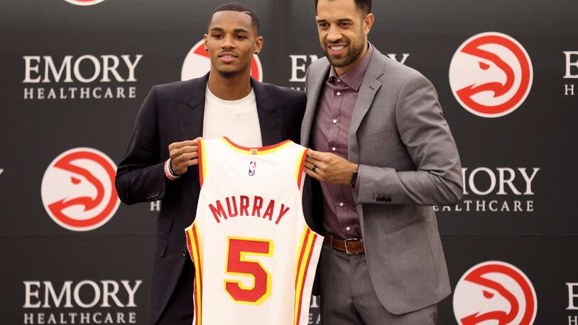Hawks guard Dejounte Murray holds his number five jersey with general manager Landry Fields during Murray’s introductory press conference at the Emory Sports Medicine Complex, Friday, July 1, 2022, in Atlanta. (Jason Getz / Jason.Getz@ajc.com)