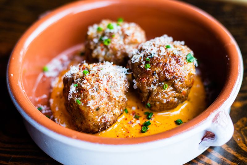 The albondigas at the Iberian Pig are made with pork and topped with a sprinkling of manchego. CONTRIBUTED BY HENRI HOLLIS