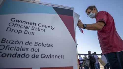 10/13/2020 - Lawrenceville, Georgia - Michael Roark of Grayson places his mail-in ballot inside an official drop box on the second day of early voting at the Gwinnett County Voter Registration and Elections building in Lawrenceville, Tuesday, October 13, 2020.  (Alyssa Pointer / Alyssa.Pointer@ajc.com)