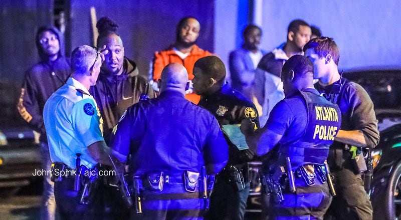 Atlanta police investigators speak with possible witnesses to a shooting in the parking lot of Anchor Down Grille and Lounge in Buckhead Friday morning. JOHN SPINK / JSPINK@AJC.COM