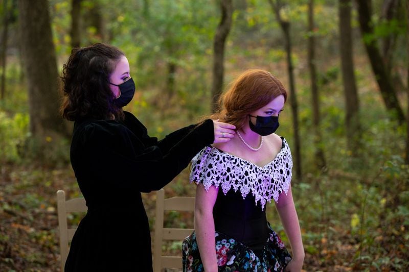 Junior Grace Lowell fixes sophomore Carys Feldman’s hair in between a performance at Cambridge High School in Milton, Georgia, on Saturday, October 31, 2020. The Cambridge High School Theatre program performed The Occurrence at Sleepy Hollow outside along the school’s trails; audience members were guided through different stages of the short story by Washington Irving. (Rebecca Wright for the Atlanta Journal-Constitution)