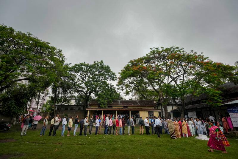 People stand in queue to cast their votes in a polling station during the third phase of general election in Guwahati, India, Tuesday, May 7, 2024. (AP Photo/Anupam Nath)