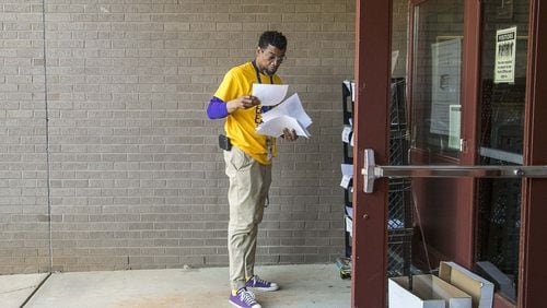 Shadow Rock Elementary School principal Ethan Suber collects packets of school work for drop-offs at the school in Lithonia, Monday, April 27, 2020. Each week Suber works with assistant principal Jason Moffitt to print out classwork for more than 100 students who do not have access to a computer or the internet. The classwork is filed in bins and left outside for parents and guardians to pick-up. A bin for completed work is also available to help teachers keep up with all of their students’ work. ALYSSA POINTER / ALYSSA.POINTER@AJC.COM