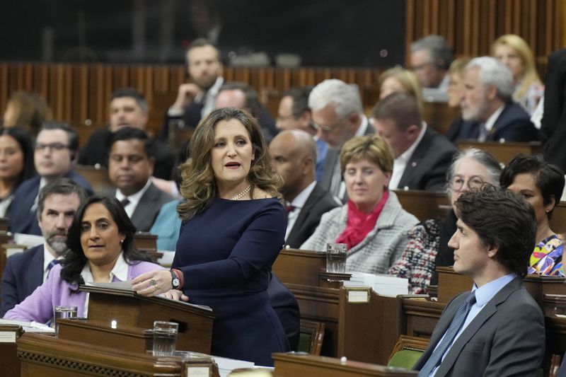 Canada's Deputy Prime Minister and Minister of Finance Chrystia Freeland rises to present the federal budget in the House of Commons in Ottawa, Ontario, as Canadian Prime Minister Justin Trudeau, lower right, listens on Tuesday, April 16, 2024. The Liberal government has already unveiled significant planks of the budget, including billions of dollars to build more homes, expand child care and beef up the military. (Adrian Wyld/The Canadian Press via AP)