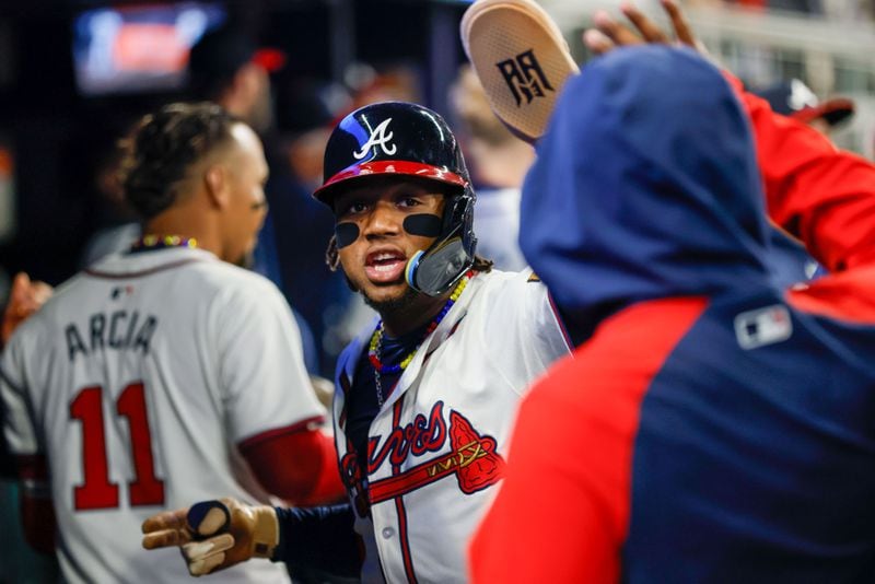 Atlanta Braves outfielder Ronald Acuña Jr. (13) celebrates with teammates at the dugout after scoring on Marcell Ozuna’s (20) home run during the first inning against the Texas Rangers at Truist Park on Sunday, April 21, 2024, in 
(Miguel Martinez/ AJC)