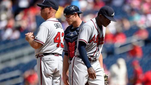 Atlanta Braves interim manager Brian Snitker (43) holds the ball after Atlanta Braves starting pitcher Tyrell Jenkins, right, was pulled from the game during the fifth inning of a baseball game against the Washington Nationals, Sunday, Aug. 14, 2016, in Washington. Also seen is Atlanta Braves catcher Anthony Recker at center. (AP Photo/Nick Wass)