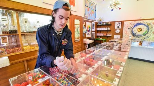 Christian Farquis serves up some candy at Henry's Candy Company Friday, April 5, 2019 on High Street i downtown Hamilton. Henry's Candy Shop offers bulk candy and chocolates. NICK GRAHAM/STAFF