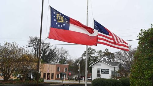 The American and Georgia state flags fly at half mast in honor of Rosalynn Carter in downtown Plains on Tuesday. She was 96 years old. (Hyosub Shin / Hyosub.Shin@ajc.com)