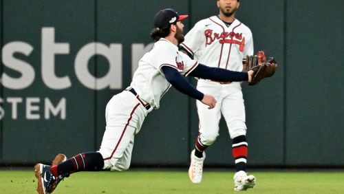 Atlanta Braves shortstop Dansby Swanson (7) makes an over the shoulder catch of the pop up by Philadelphia Phillies’ J.T. Realmuto during the sixth inning of Game 2 of the National League Division Series at Truist Park in Atlanta on Wednesday, Oct. 12, 2022. (Hyosub Shin / Hyosub.Shin@ajc.com)