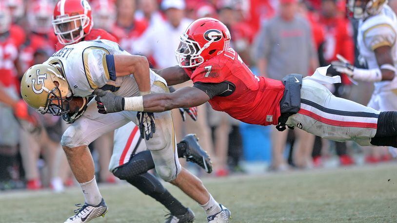 November 29, 2014 Athens - Georgia Tech Yellow Jackets running back Zach Laskey (37) gets tackled by Georgia Bulldogs linebacker Lorenzo Carter (7) during the overtime play at Sanford Stadium in Athens on Saturday, November 29, 2014. In the 109th playing of the Tech-Georgia game, the No. 16 Yellow Jackets ended the No. 9 Bulldogs' five-game winning streak in the series with a 30-24 overtime win at Sanford Stadium Saturday afternoon. HYOSUB SHIN / HSHIN@AJC.COM