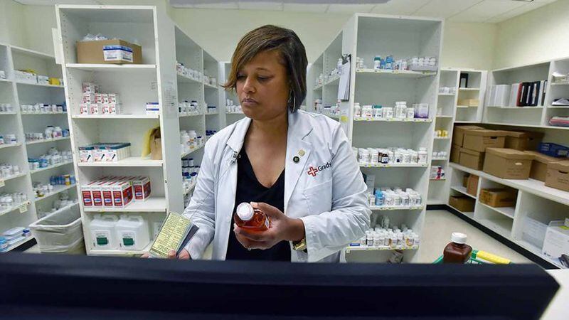  Pharmacist Bridget McCord prepares prescriptions at Grady Memorial Hospital. It charges $5 or less to thousands of low-income and uninsured outpatients.